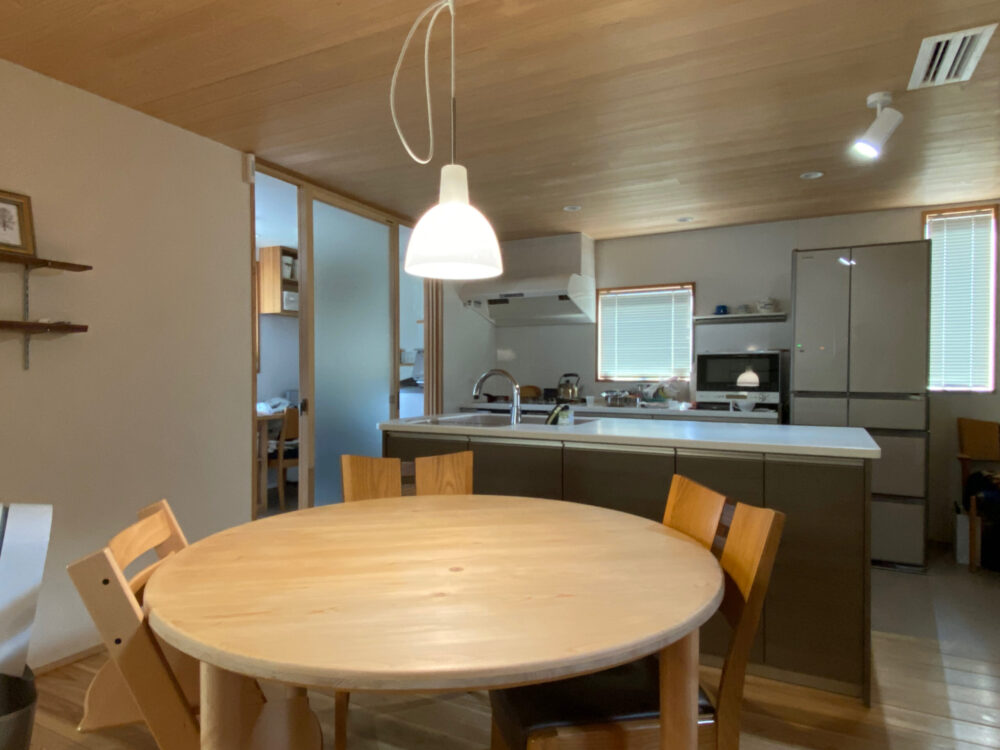 Ⅱ型のキッチン、丸テーブル、サンルームの建具と3つの小さな回遊動線がある