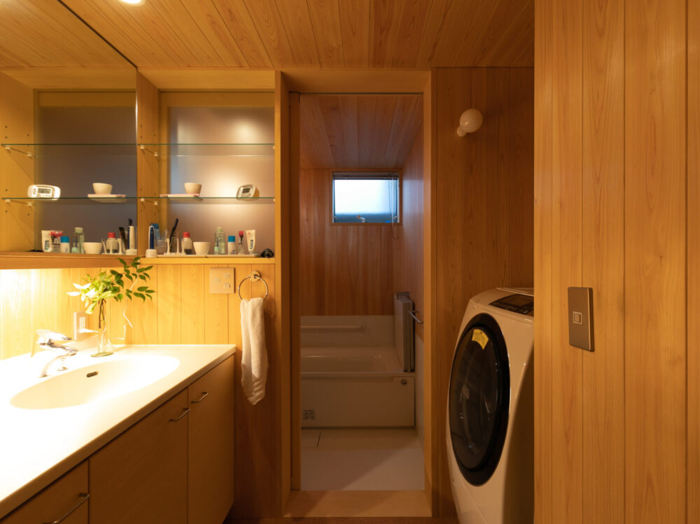 板貼りで統一された豊中の家の脱衣室・浴室。仕上げの素材を変えないことで空間にこれだけの広がりをもたらすことができる