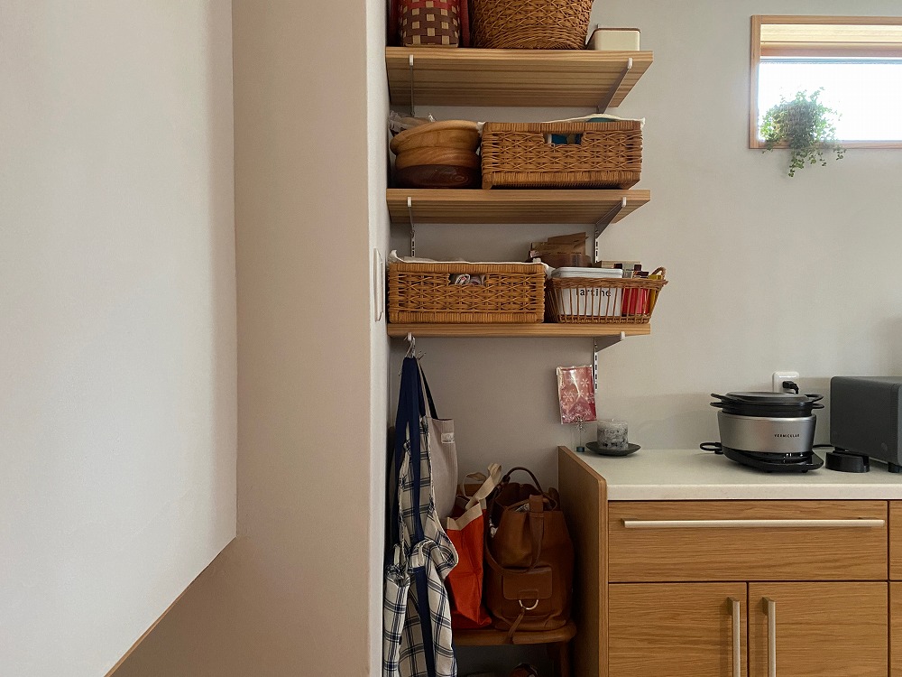 鞄置き場として使っているオープン棚の足元。通路をふさがず、棚や椅子にも置かない